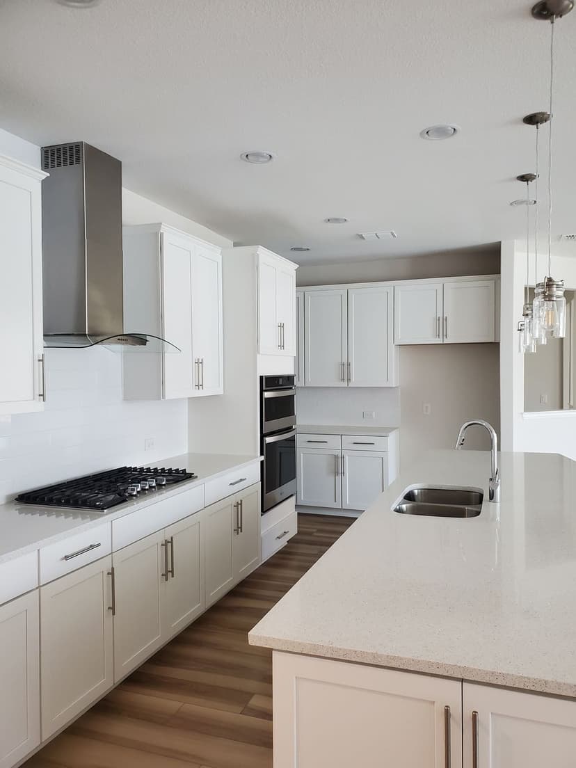 Modern kitchen with white cabinetry, stainless steel appliances, and an island countertop.